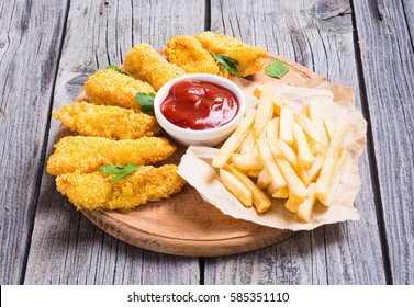 Chicken Strips And French Fries  On Rustic Wooden Background