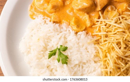 Chicken strogonoff with rice and french fries (potato sticks) on dish. Chicken stroganoff, is a dish originating from Russian cuisine.