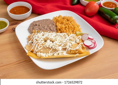 Chicken tamales served in an authentic Mexican restaurant. Spicy tamales served with rice and beans. Handmade tamales wrapped in corn husk and topped with cheese.