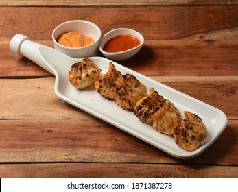 Chicken Tandoori Momo Served With Sauce Over A Rustic Wooden Background, Selective Focus