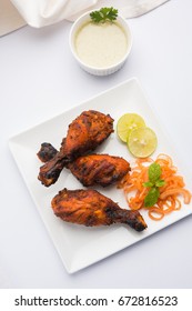 Chicken Tangri kabab or kebab - three Chicken leg pieces marinated with red sauce then grilled and served with salad. It can be served with green chutney