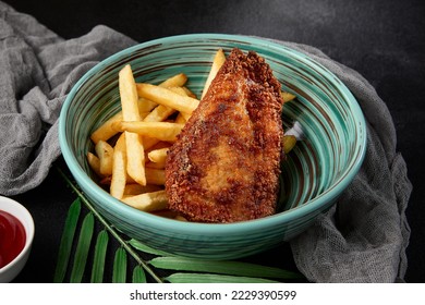 Chicken tenders with french fries in bowl on black backdrop. Junk food on dark stone background. Crispy chiken fillet with potatoes in minimal style. Combo with fried chicken breast and potatoes - Shutterstock ID 2229390599