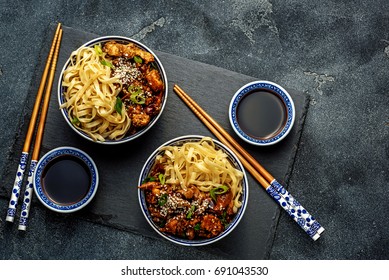 Chicken teriyaki on dark background with balsamic sauce and sesame seeds. Asian food. Noodles. Top view. - Shutterstock ID 691043530