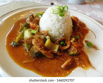 
		chicken teriyaki and veggies on a plate topped with white rice			