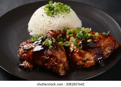 Chicken thighs marinated and cooked in adobo sauce. National filipino dish. Adobo with rice close-up on a plate. 