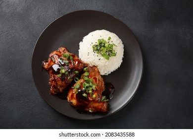 Chicken thighs marinated and cooked in adobo sauce. National filipino dish. Adobo with rice close-up on a plate. 