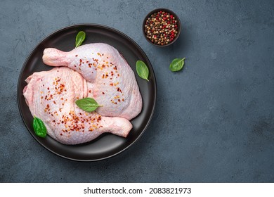 Chicken thighs in a plate on a dark background with spices and basil. Top view, copy space. Cooking. - Shutterstock ID 2083821973
