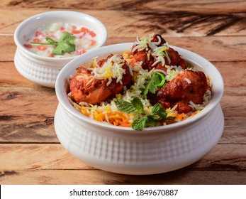 Chicken Tikka Biryani made of Basmati rice cooked with masala spices, served with yogurt, selective focus