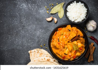 Chicken Tikka Masala with rice and bread - traditional indian dish. Top view with copy space on black stone table. - Powered by Shutterstock