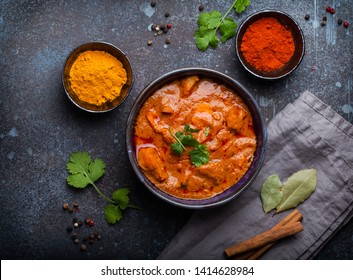 Chicken tikka masala with spicy curry meat served in rustic ceramic bowl, popular Indian dish, on concrete background, top view