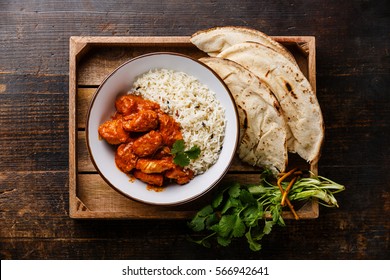 Chicken tikka masala spicy curry meat food Butter chicken with rice and naan bread in tray on wooden background