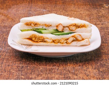 chicken tikka sandwich in a dish on dark wooden background side view