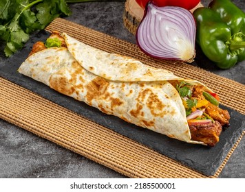 Chicken Tikka shawarma Wrap served in a cutting board on grey background side view of fastfood
