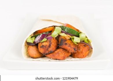 Chicken Tikka Wrap - BBQ Tandoori Chicken Tikka With Salad Wrapped In A Flatbread On A White Background.