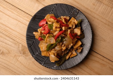 pollo salteado, tofu, pimientos, cebollas con pimienta negra. Comida indonesia. pimienta negra con tofu de pollo. ayam Tahu lada hitam.