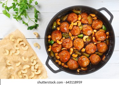 Chicken Or Turkey Meatballs Stewed With Green Bell Pepper, Onion, Soy Sauce, Chinese Cooking Wine And Spices In Pan On White Wooden Table, View From Above