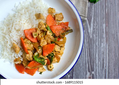 Chicken And Vegetable Sauté With Rice On A White Plate