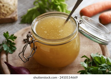 Chicken and vegetable soup or bone broth in a glass jar