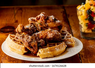 Chicken And Waffles. Crispy Homemade Fried Chicken On Top Of Homemade Buttermilk Waffles Topped With Butter And Maple Syrup. Classic American Diner Style Breakfast Or Brunch Menu Item Favorite.