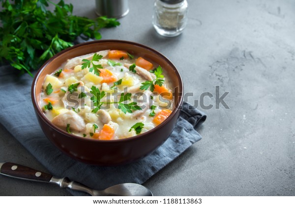 Chicken\
and Wild Rice Soup. Homemade fresh creamy soup with chicken,\
vegetables and wild rice in white bowl close\
up.