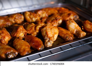 Chicken wings baked on a stainless steel tray in the microwave. - Shutterstock ID 1740196004