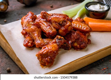 chicken wings in barbecue sauce and with blue cheese sause on dark rustic concrete table