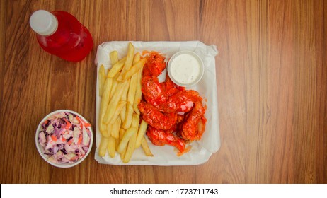 Chicken Wings In Buffalo Sauce With Soda And Coleslaw On A Wooden Table Top View