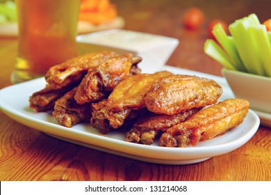 chicken wings with celery, carrot and glass of beer