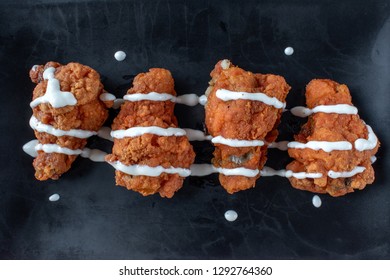 Chicken Wings With Drizzle Of White Sauce Top Down On Dark Background