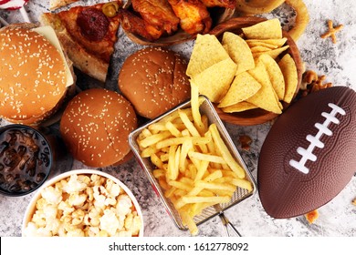 chicken wings, fries, and onion rings for football on a table. Great for Bowl football Game. and other unhealthy food with salt, fat and sugar