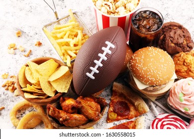 Chicken Wings, Fries, And Onion Rings For Football On A Table. Great For Bowl Football Game. And Other Unhealthy Food With Salt, Fat And Sugar