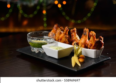 Chicken wings grilled with sauce,on a dark plate