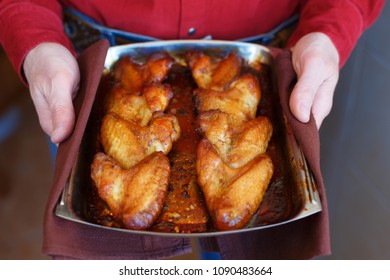 Chicken Wings In Honey Sauce Are Baked In The Oven On A Baking Sheet At Home. Wings Of Barbecue Cooking. Man Is Holding Chicken Wings On A Baking Sheet