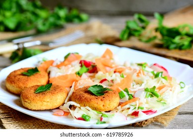 Chickpea cutlets and fresh vegetable salad on a plate. Fried chickpea cutlets. Cabbage salad with carrot, radish, green onions and parsley. Veggie lunch or dinner recipe. Rustic style. Closeup - Powered by Shutterstock