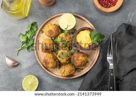 Chickpea falafel with lime and sauce on a plate and grey background top view Stock photo © 