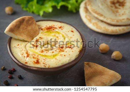 Chickpea hummus in a bowl and pita bread on grey background. Mediterranean snack, vegetarian healthy food concept. Top view, flat lay, copy space. Stok fotoğraf © 