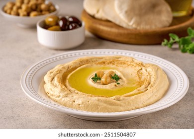 Chickpea hummus plate with pita bread and olives. Closeup view, selective focus