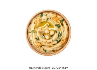 Chickpea hummus in a wooden bowl garnished with parsley, paprika and olive oil isolated on white background. Top view