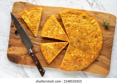 Chickpea pancake Farinata with rosemary herb. Homemade traditional Italian cuisine dish cut in pieces. - Shutterstock ID 2148533353