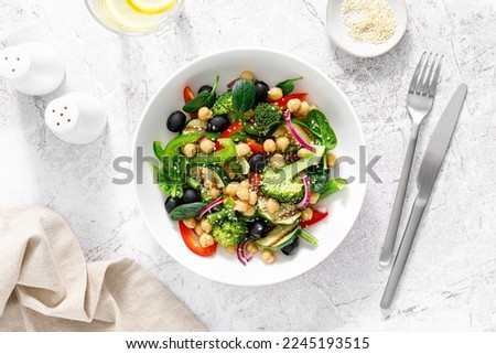 Chickpea and spinach vegan vegetable salad with broccoli, sweet pepper, olives and grilled zucchini. Mediterranean diet, healthy food. Top view