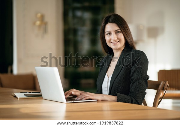The chief Accountant of the Student to the\
fundamentals of the economy. Online training in a modern office. An\
economist in a business suit. Sitting in a chair and reading on an\
electronic textbook.