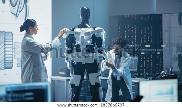 Chief Analyst\
Uses Computer, Female Engineer and Top Male Scientist Work on a\
Bionics Exoskeleton Prototype. Designing Powered Exosuit to Help\
Disabled People, Hard Labor\
Workers
