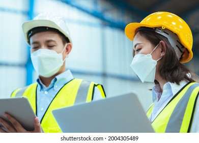 Chief industrial engineer inspects the mask factory. Discuss new projects while using a laptop. They showed an assertive attitude. There are employees wearing protective gear working diligently. - Powered by Shutterstock