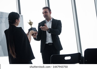 Chief trophy to women employees to work successfully. Female employees received awards from the head after his performance was excellent. Concept of successful work for the company.