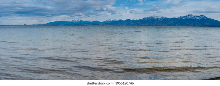 Chiemsee lake panorama in spring in sunny day with Alps mountains in the background.