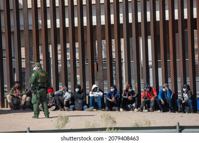 Juárez Chihuahua Mexico 11-22-2021 group of migrants surrenders to a border patrol agent after crossing the border between Mexico and the United States