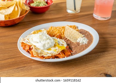 Chilaquiles served for breakfast or brunch. A mexican dish made with eggs, refried beans, and corn tortilla chips.
