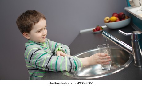 Child - 7 Year Old Boy Pouring Tap Water Into A Glass