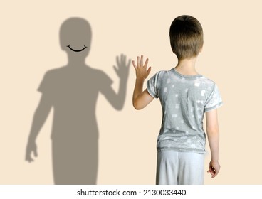 child 8-10 years old in gray t-shirt extended his hand to his shadow, concept imaginary friend, problems of loneliness, self-knowledge, psychology of childhood, personality development of teenager