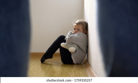 Child Abuse Concept. Mistreated Little Girl Seating On The Floor And Scared Of Adult.